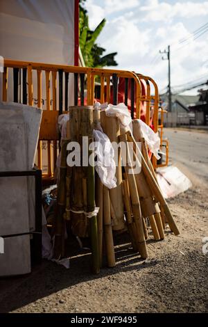 Una grande pila di bambù è impilata ordinatamente sul lato di una strada, in attesa di essere trasportata o utilizzata per la costruzione. Foto Stock