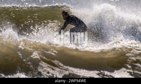 Gilgo Beach, New York, USA - 31 agosto 2023: Primo piano di un uomo che fa surf in un Oceano Atlantico molto ruvido. Foto Stock