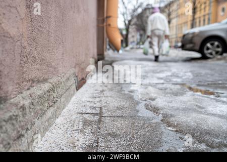 Grani di sale tecnici sulla superficie del marciapiede ghiacciato in inverno, utilizzati per sciogliere ghiaccio e neve Foto Stock