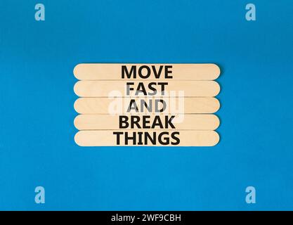 Muoviti in fretta e rompi il simbolo. Le parole concettuali si muovono velocemente e rompono le cose su un bastone di legno. Bellissimo sfondo blu. Affari, muoviti in fretta Foto Stock