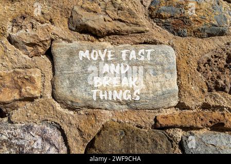 Muoviti in fretta e rompi il simbolo. Le parole concettuali si muovono velocemente e rompono le cose su una pietra bellissima. Splendido sfondo murale in pietra. Affari, muoviti in fretta a. Foto Stock