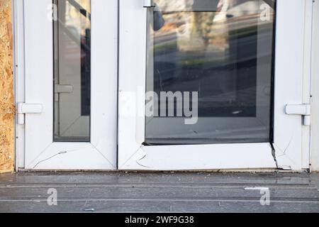 Una porta di vetro in metallo-plastica si è rotta da un'onda esplosiva durante un attacco missilistico al Dnieper in Ucraina, guerra in Ucraina Foto Stock