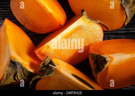 persimmon a fette su sfondo nero Foto Stock