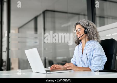 Donna anziana e felice agente professionale del contact centre che lavora in ufficio. Foto Stock