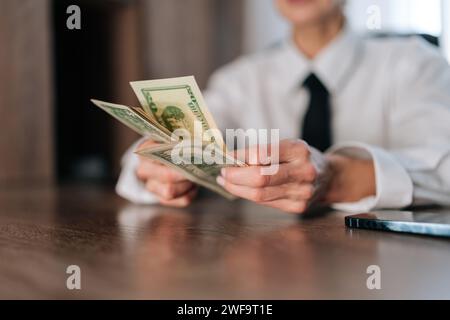 Ravvicinare le mani femminili del conteggio della valuta americana. Closeup ha tagliato una foto di una donna d'affari che conta soldi in contanti banconote da uno, cinque, dieci, venti Foto Stock