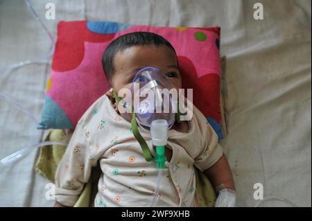 Sylhet, Bangladesh. 29 gennaio 2024. Un bambino in cura per problemi respiratori al Sylhet MAG Osmani Medical College Hospital. I bambini di età compresa tra i sei mesi e l'anno e mezzo si precipitano in ospedale con polmonite e complicazioni da broncopolmonite. Il 29 gennaio 2024 Sylhet, Bangladesh (foto di Rafayat Haque Khan/ Eyepix Group/Sipa USA) credito: SIPA USA/Alamy Live News Foto Stock