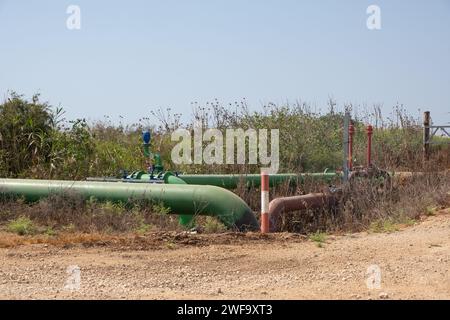 Conduttura di erogazione dell'irrigazione industriale ai campi, un sistema idrico per i campi agricoli. tubi di ferro che si diramano con acqua in terre aride nella so Foto Stock