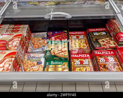 Italia - 26 gennaio 2024: Pizze surgelate precotte in confezioni di varie marche esposte in un banco refrigerato in vendita in un supermercato italiano, t Foto Stock