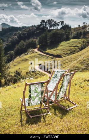 Sedie in legno, con tessuti vegetali, nelle verdi montagne. Foto Stock