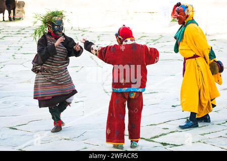 Tre monaci danzanti mascherati da maschere per simboleggiare diete e clown nella loro religione eseguono danze rituali per la gente del posto ogni anno in un annu Foto Stock