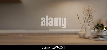 Immagine ravvicinata di un tavolo in legno con libri, decorazioni di piante e uno spazio per la riproduzione del prodotto. un tavolo da pranzo in legno in un kitc minimalista Foto Stock