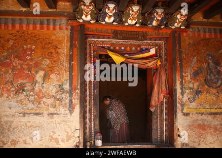 L'uomo bhutanese porta una posta di ferro per la penitenza, un atto tradizionale che la gente del posto si impegna al tempio Tamshing Lhakhang, nella Valle di Bumthang, in Bhutan Foto Stock