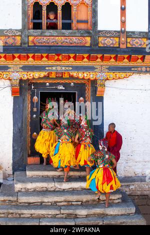 Un ragazzo che sbircia attraverso una finestra aperta guarda i monaci mascherati entrare nel tempio dopo aver ballato per la gente del posto all'annuale festival Prakhar Foto Stock