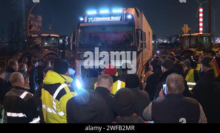 Amburgo, Germania. 30 gennaio 2024. Un camion è bloccato in un blocco da parte degli agricoltori in un incrocio con accesso al porto a sud di Amburgo. Le proteste degli agricoltori sono proseguite martedì sera. Gli agricoltori continuano a paralizzare le principali arterie di traffico intorno al porto di Amburgo. L'azione ha conseguenze di vasta portata per i fornitori e comporta notevoli ostacoli al traffico. Crediti: Steven Hutchings/dpa/Alamy Live News Foto Stock