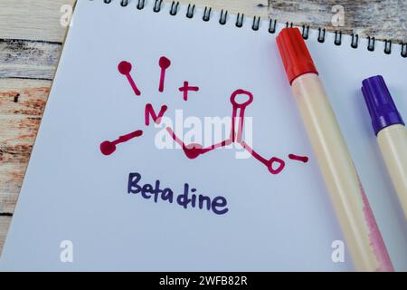 Concetto di Betadine scrivere su libro isolato su tavolo di legno. Foto Stock