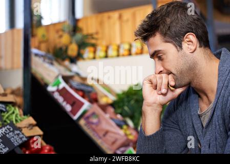 Pensare, mangiare e fare shopping in un supermercato per promozioni alimentari, sconti o sconti. Inflazione, costi o clienti che acquistano generi alimentari per Foto Stock
