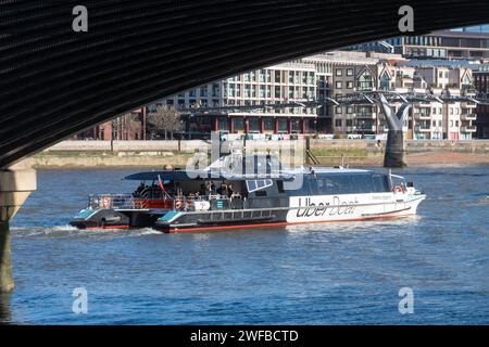 Uber Boat by Thames Clippers dopo aver passato sotto il ponte ferroviario Blackfriars, avvicinandosi al Millennium Bridge, Londra, Inghilterra, Regno Unito Foto Stock