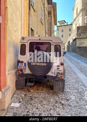 Castell'Arquato, Italia - giugno 25 2023 Land Rover Defender 90, classico osso bianco degli anni '90, corto parcheggiato in salita nel borgo medievale Foto Stock