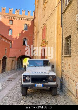 Castell'Arquato, Italia - giugno 25 2023 Land Rover Defender 90, classico osso bianco degli anni '90, corto parcheggiato in salita nel borgo medievale Foto Stock