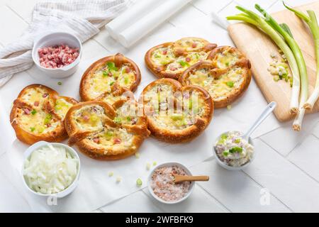 Deliziosi brezeln bavaresi fatti in casa o pretzel cotti con formaggio cremoso, pancetta e cipolle Foto Stock