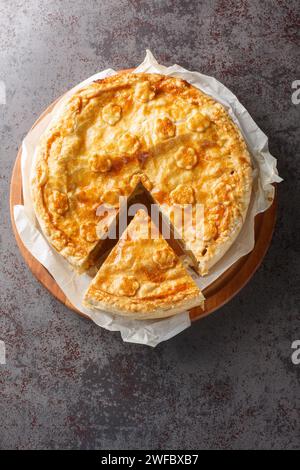 Il colera è una tradizionale torta svizzera ripiena di patate, cipolle, formaggio e mele per primo piano sulla tavola di legno sul tavolo. Vista superiore verticale da a. Foto Stock