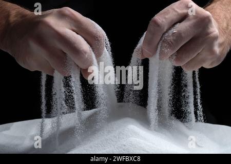 sabbia che scorre attraverso le mani come un simbolo per il tempo di corsa. Foto Stock