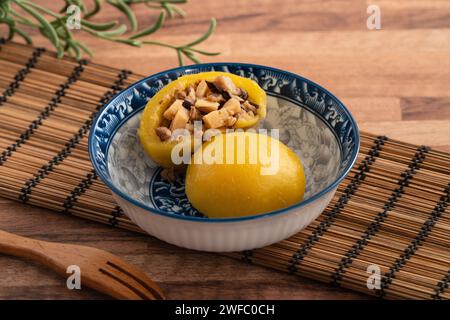 Panino di patate dolci fatto in casa con carne di maiale macinata, funghi e farciture di bambù tritate all'interno in una ciotola su fondo di legno. Foto Stock