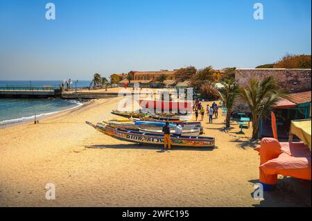 Barche da pesca sulla spiaggia sabbiosa di Goree Island con oceano e molo, Senegal Foto Stock