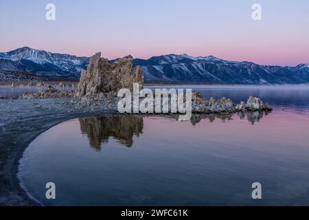 Prima dell'alba nebbia sulle formazioni di tufo sul lago Mono in California. Le montagne della Sierra orientale sono dietro. Foto Stock