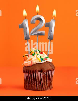 Candela numero 121 - cupcake di compleanno su sfondo arancione Foto Stock