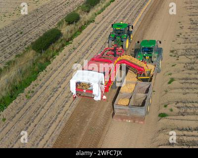 Vista aerea dei trattori che raccolgono le patate, Pembrokeshire Galles Regno Unito Foto Stock