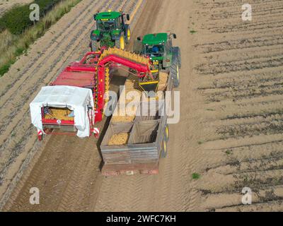 Vista aerea dei trattori che raccolgono le patate, Pembrokeshire Galles Regno Unito Foto Stock