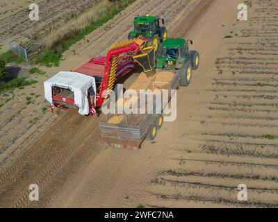 Vista aerea dei trattori che raccolgono le patate, Pembrokeshire Galles Regno Unito Foto Stock