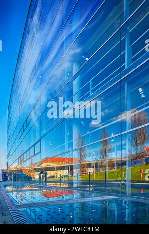 Facciata di alti edifici d'affari con un incredibile riflesso di un intero paesaggio e del cielo blu Foto Stock