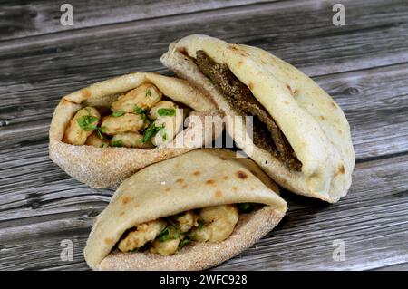 Gamberetti fritti con farina, fette di fegato di manzo con crusca fritta in olio e servita con prezzemolo in un tradizionale pane piatto egiziano con crusca di grano A. Foto Stock