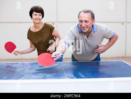 Felice matura spousesn giocare a ping pong Foto Stock