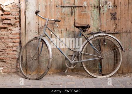 Marocco, Marrakech, Marrakesh, scena di strada marocchina nel quartiere vecchio della medina, bicicletta d'epoca con pneumatici sgonfi, vecchia serie di porte Foto Stock