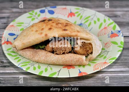 Cervello di mucca ricoperto di farina e fritto con olio caldo profondo, un panino di cervello fritto in un tradizionale pane piatto egiziano con crusca di grano e farina, Foto Stock