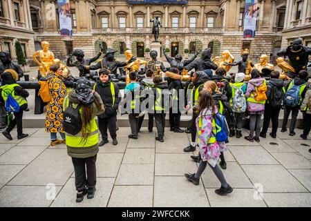 Londra, Regno Unito. 30 gennaio 2024. Una festa scolastica della Chapel End Junior Academy esamina la nuova scultura di Tavares Strachan The First Supper, 2021-23, nel cortile Annenberg come parte della nuova mostra entangled Pasts: 1768-Now: Art, colonialism and Change, presso la Royal Academy of Arts La prima cena rappresenta ciò che Strachan descrive come un raduno utopico che riunisce figure storicamente significative del continente africano e delle sue diaspore, accompagnate da una tigre tilacina o Tasmania e da un ritratto dell'artista. Include ritratti scultorei del combattente della resistenza Zumbi Foto Stock