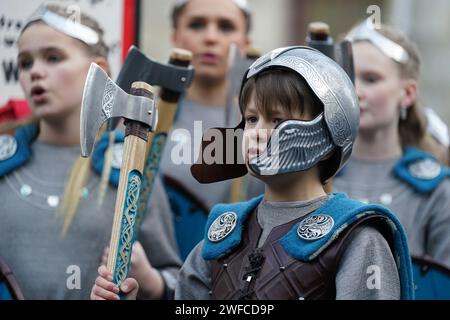 Membri della Jarl Squad che marciavano attraverso Lerwick sulle isole Shetland durante il festival Up Helly AA. Nato negli anni '1880, il festival celebra il patrimonio norreno delle Shetland. Data immagine: Martedì 30 gennaio 2024. Foto Stock