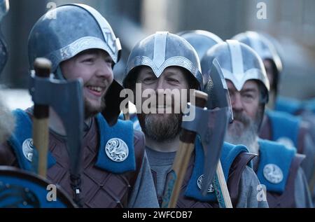 Membri della Jarl Squad che marciavano attraverso Lerwick sulle isole Shetland durante il festival Up Helly AA. Nato negli anni '1880, il festival celebra il patrimonio norreno delle Shetland. Data immagine: Martedì 30 gennaio 2024. Foto Stock