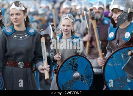 Membri della Jarl Squad che marciavano attraverso Lerwick sulle isole Shetland durante il festival Up Helly AA. Nato negli anni '1880, il festival celebra il patrimonio norreno delle Shetland. Data immagine: Martedì 30 gennaio 2024. Foto Stock