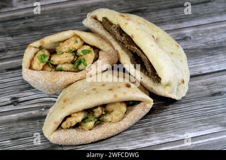 Gamberetti fritti con farina, fette di fegato di manzo con crusca fritta in olio e servita con prezzemolo in un tradizionale pane piatto egiziano con crusca di grano A. Foto Stock