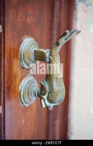 Immagine a colori ravvicinata di un battente in metallo d'epoca su una porta di legno. Foto Stock