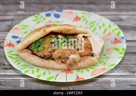 Cervello di mucca ricoperto di farina e fritto con olio caldo profondo, un panino di cervello fritto in un tradizionale pane piatto egiziano con crusca di grano e farina, Foto Stock