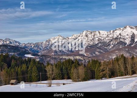 Una collina innevata con torreggianti montagne nella regione di Hallstatt Dachstein, patrimonio dell'umanità dell'UNESCO Foto Stock