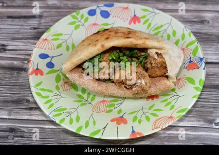 Cervello di mucca ricoperto di farina e fritto con olio caldo profondo, un panino di cervello fritto in un tradizionale pane piatto egiziano con crusca di grano e farina, Foto Stock