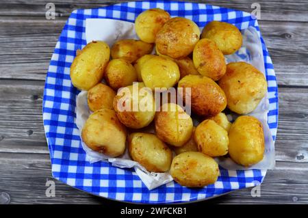 Palle di patate fritte, precedentemente bollite in acqua calda e poi fritte in olio per alimenti profondi, fast food con patate come contorno o spuntino, serviti in un piatto Foto Stock