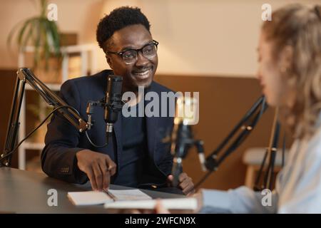 Amichevole conduttore di podcast maschile che parla con l'ospite Foto Stock