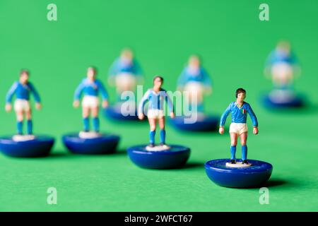 Un gruppo di figure in miniatura Subbuteo dipinte nei colori della nazionale italiana di maglia blu e pantaloncini bianchi. Subbuteo è una partita di calcio da tavolo Foto Stock
